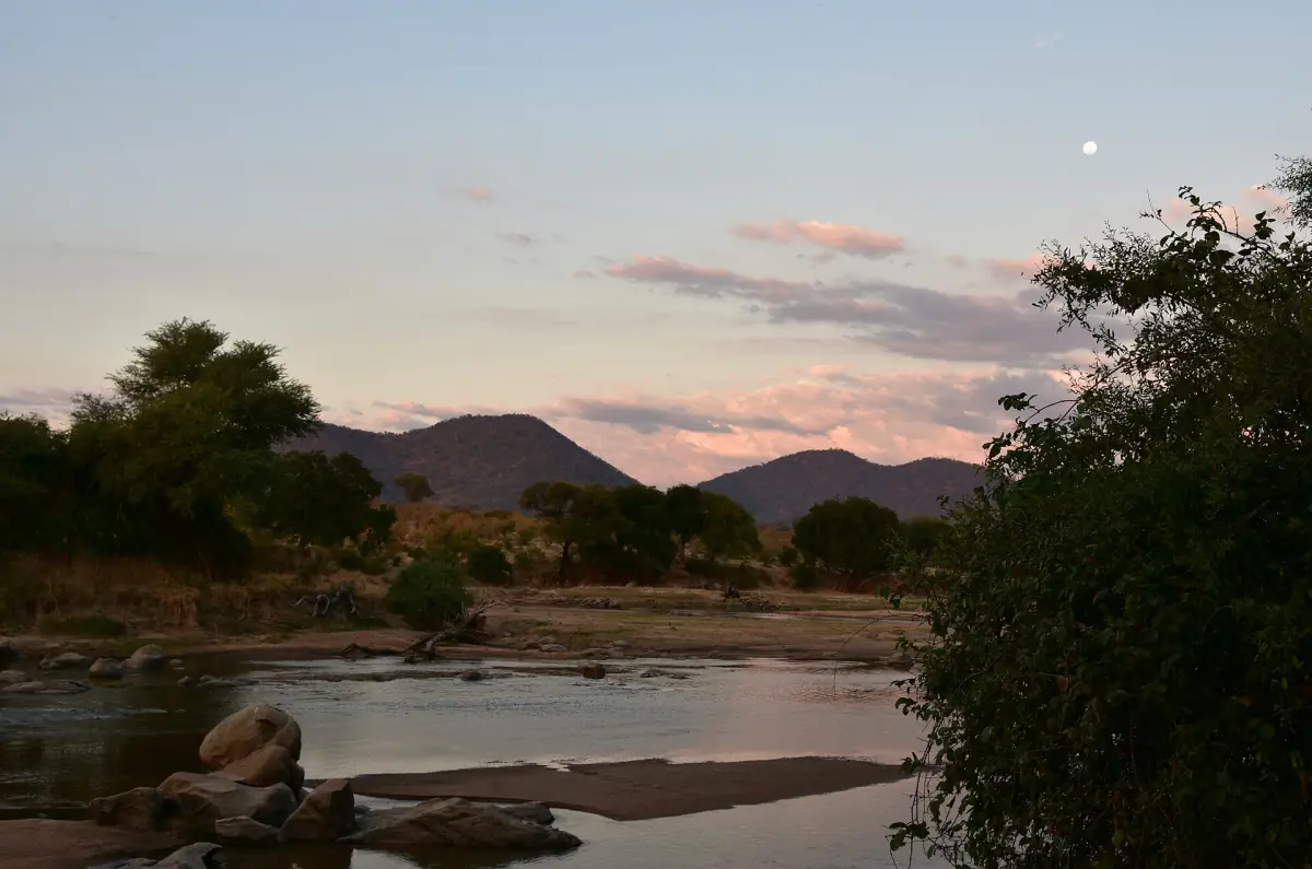 Ruaha-rivier in de schemering met een roze hemel en donkere heuvels